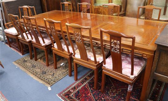 A Chinese hardwood extending dining table, with 2 spare leaves W.275cm